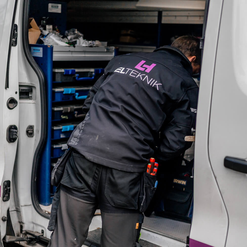 nærbillede af Elektriker der kigger i sin firmabil