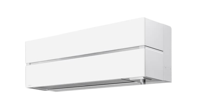 Hvid Mitsubishi luft til luft varmepumpe monteret højt på væggen med et enkelt og moderne design. Enheden er klar til at opvarme eller køle hjemmet energieffektivt.